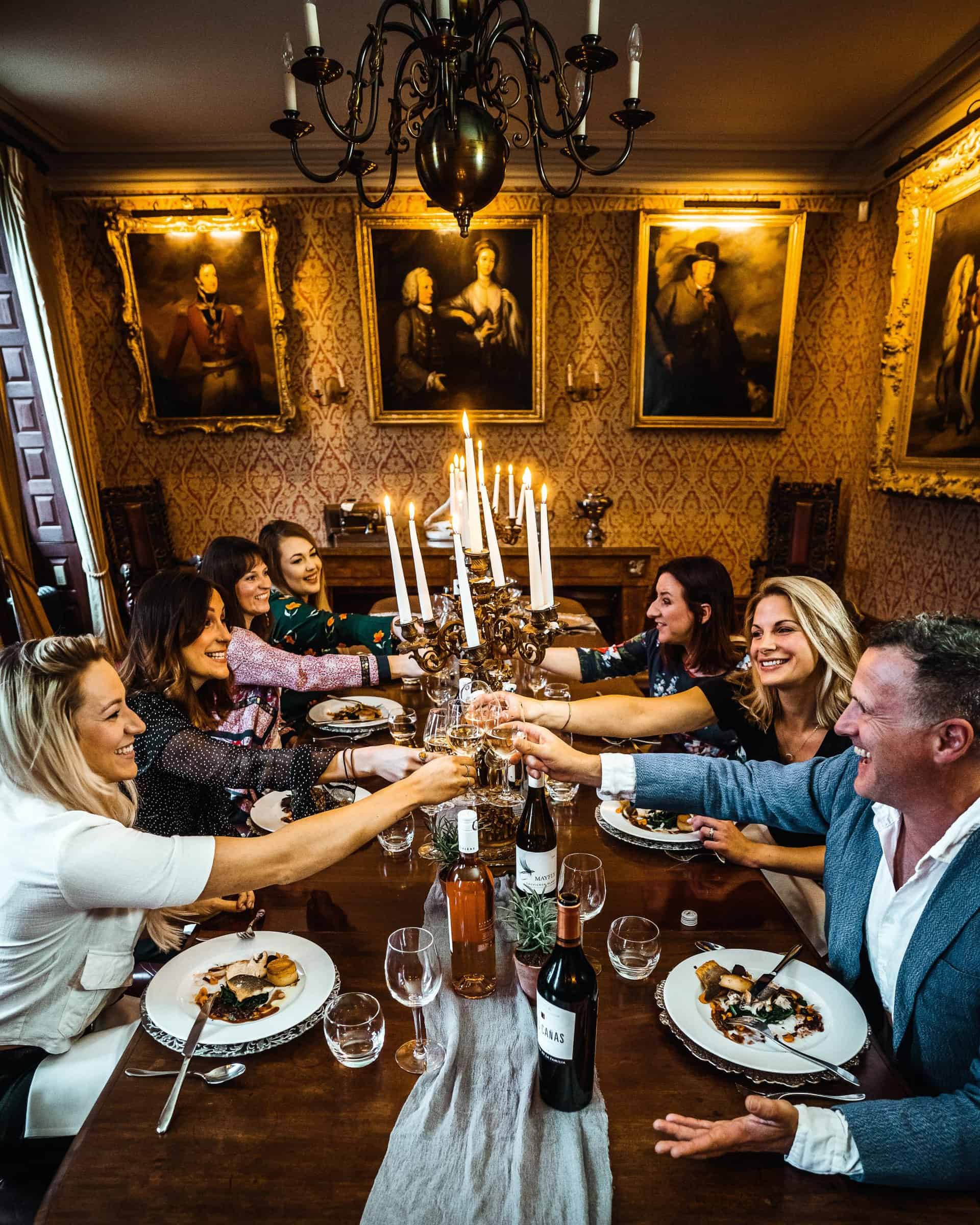 A group of people toasting at a dinner table.